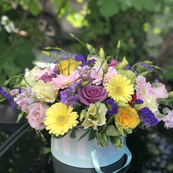 Mixed pastel bouquet in a striped round box with a ribbon