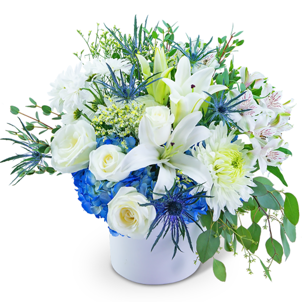 White lilies and roses in a white vase with blue hydrangea accents