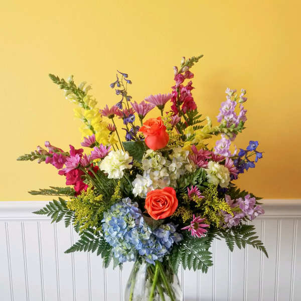 Colorful mixed flower arrangement in a clear glass vase
