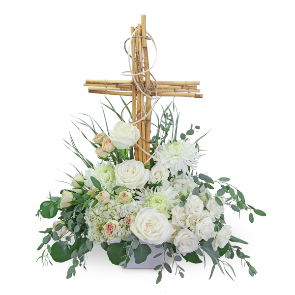 White floral arrangement with a wooden cross centerpiece