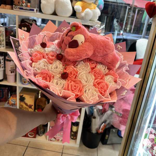 Pink and white rose bouquet with a plush bear topper