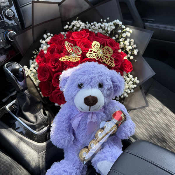 Red rose bouquet with baby’s breath and a purple teddy bear in a car seat
