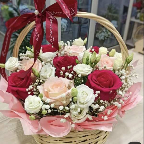 Basket of pink, red, and white roses with baby's breath and a red ribbon