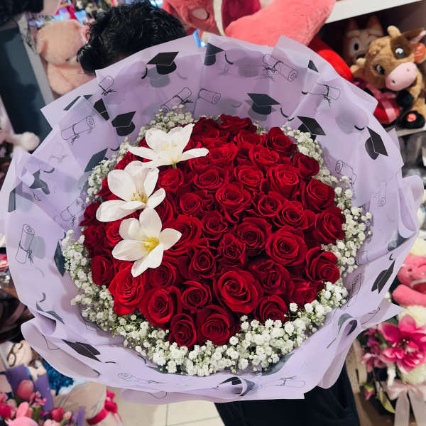 Bouquet of red roses with white flowers wrapped in lavender paper
