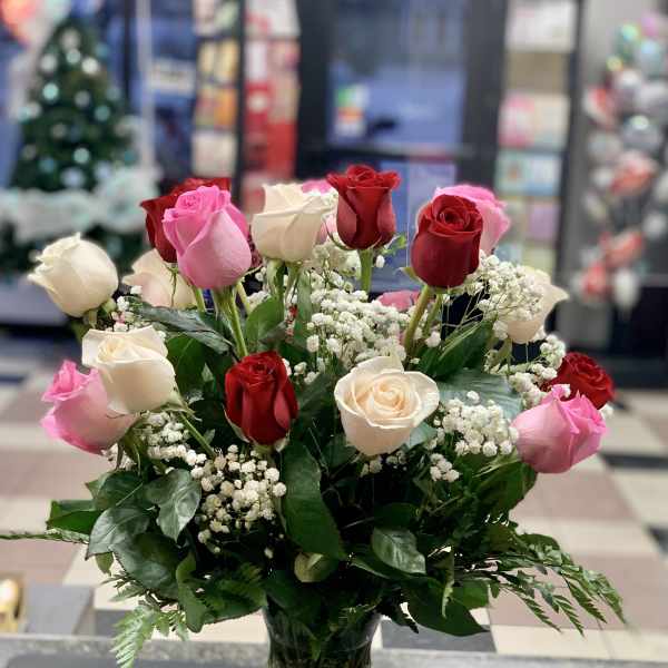 Bouquet of red, pink, and white roses in a clear glass vase