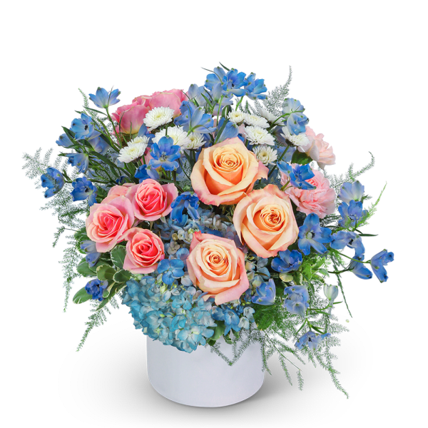 Bouquet of peach and pink roses with blue flowers in a white vase