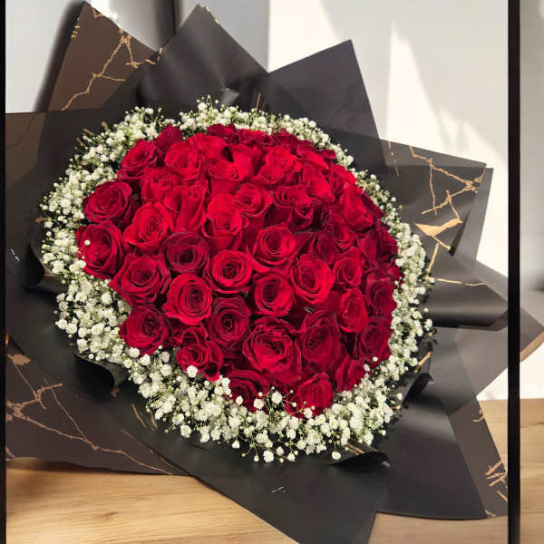 Bouquet of red roses with white baby's breath in black wrapping