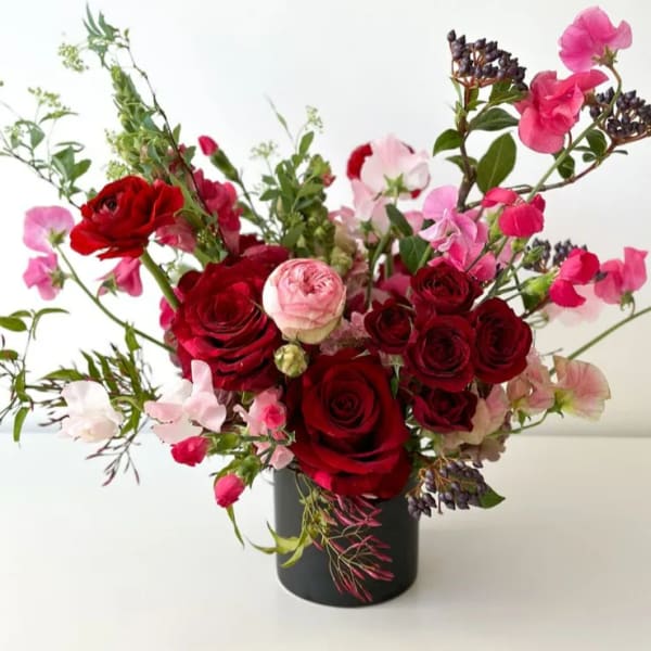 Red and pink roses arranged in a black vase