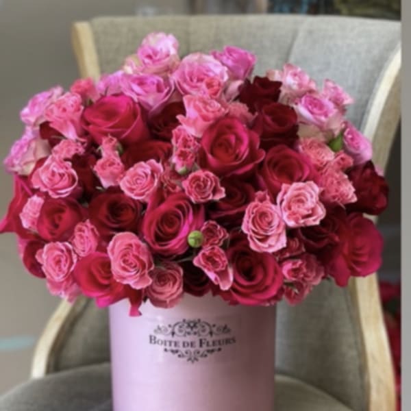 Pink and red roses arranged in a round hatbox