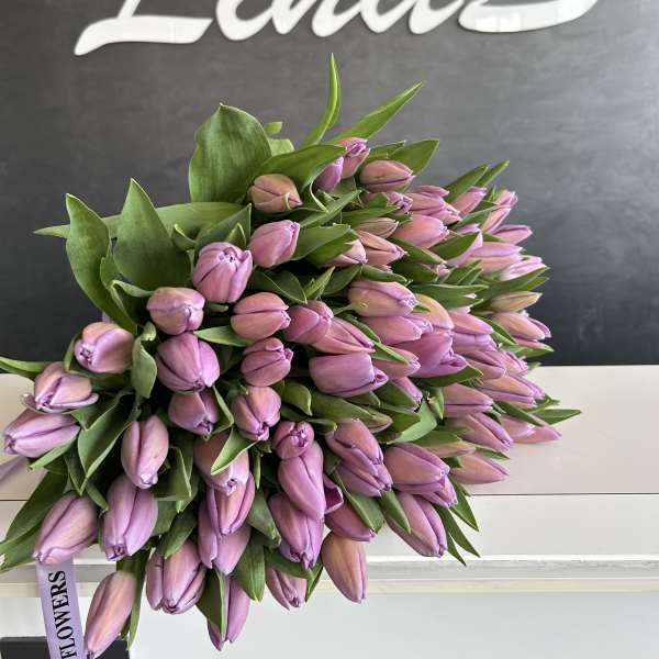 Large bouquet of pink tulip buds with green leaves