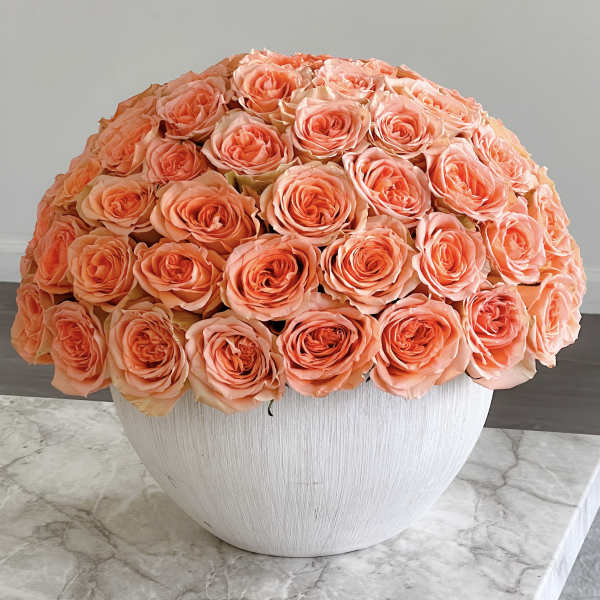 Peach rose bouquet in a white bowl vase