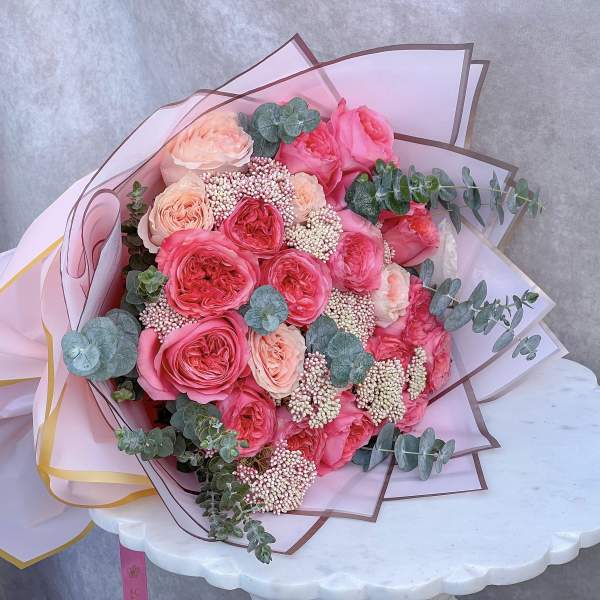 Pink and peach rose bouquet wrapped in pale pink paper