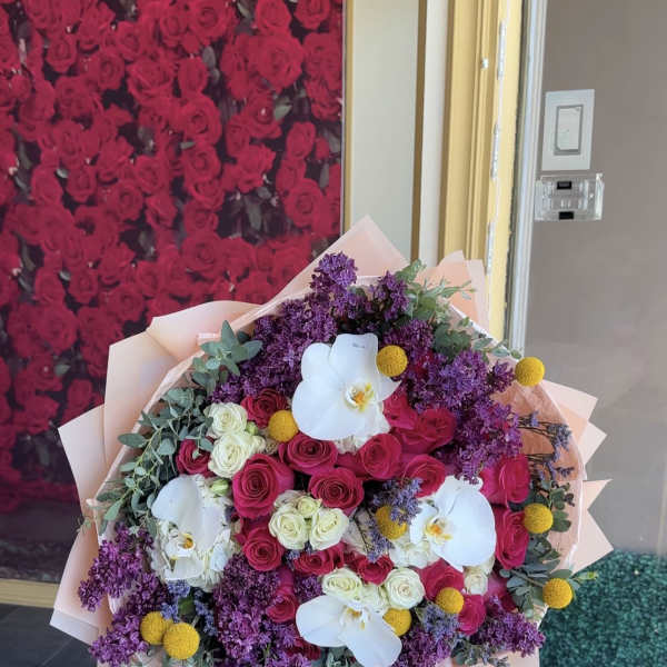 Large bouquet of pink and white roses with white orchids and purple flowers