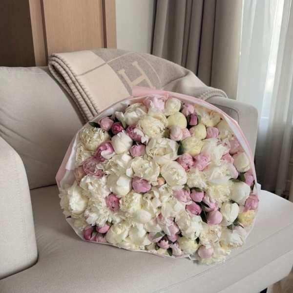 Large bouquet of pale pink and white flowers wrapped in pink paper
