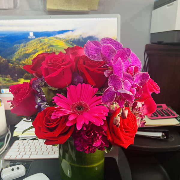 Pink and red flower arrangement in a green vase