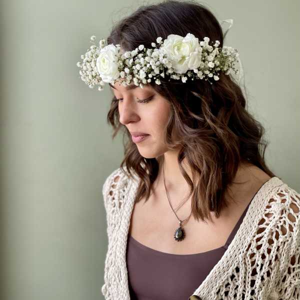 Woman wearing a white floral crown with small white blooms