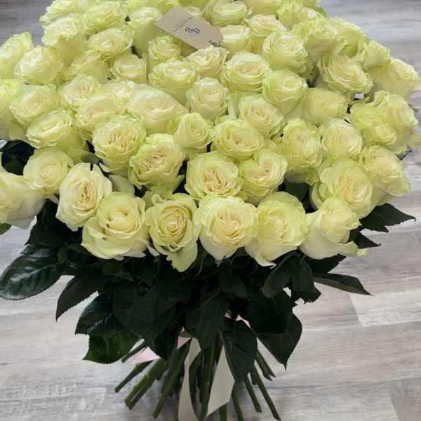 Large bouquet of pale yellow roses with dark green foliage