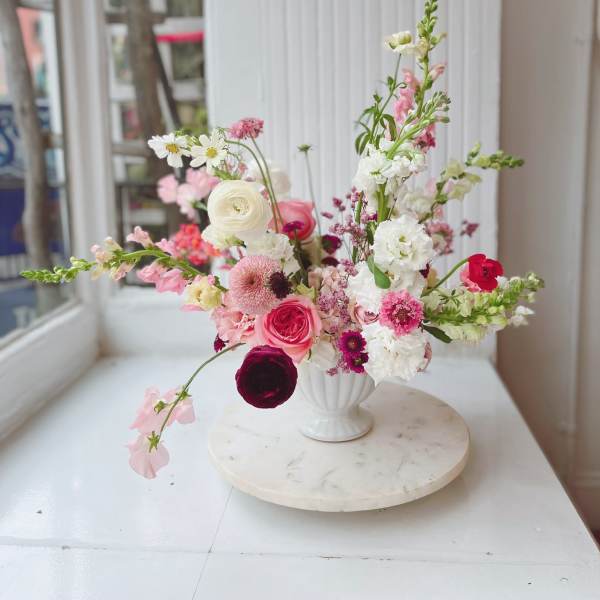 Pink and white mixed flower arrangement in a white vase