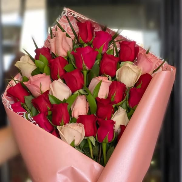 Bouquet of red and blush roses wrapped in pink paper