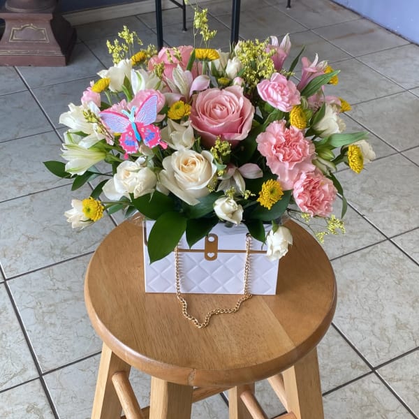 Pink and white flower arrangement in a white gift box