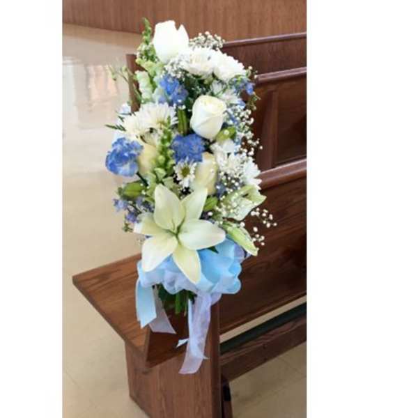 Tall blue and white floral arrangement with ribbon on a wooden stand