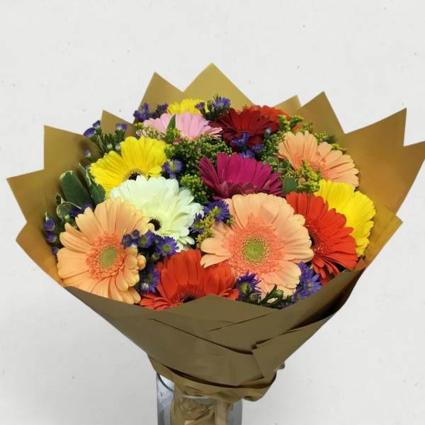 Bouquet of multicolored gerbera daisies wrapped in brown paper