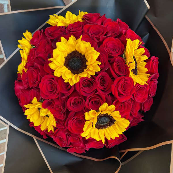 Bouquet of red roses with yellow sunflowers wrapped in black paper