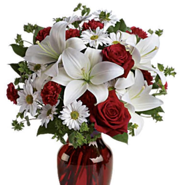 Red roses and white lilies in a red glass vase