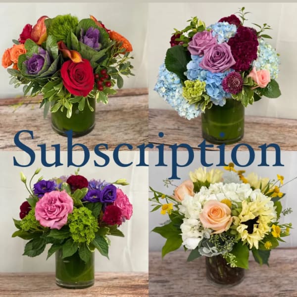 Four colorful flower arrangements in glass vases on a wooden surface