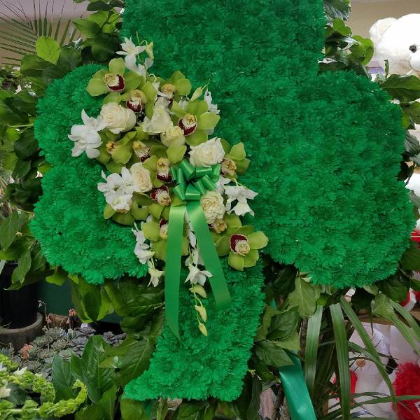 Green floral standing tribute with white orchids and roses