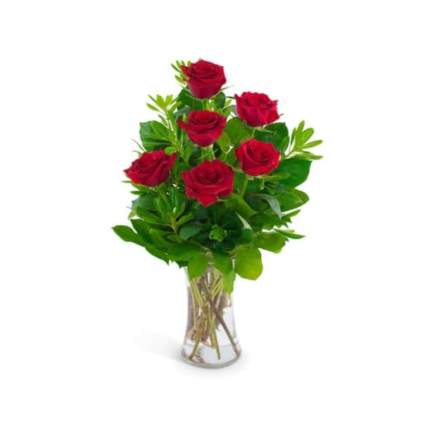 Red roses arranged in a clear glass vase