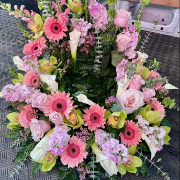 Pink and white floral wreath with gerbera daisies, roses, and calla lilies