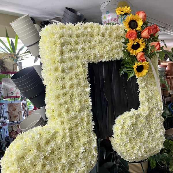 Large floral number-shaped display made of white chrysanthemums with sunflowers and roses