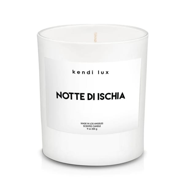 White scented candle in a glass jar with a printed label
