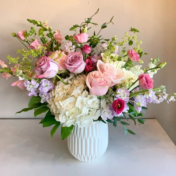 Pink and white rose bouquet in a white vase