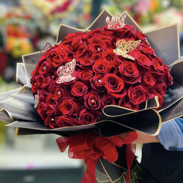 Bouquet of red roses with black wrapping and butterfly decorations