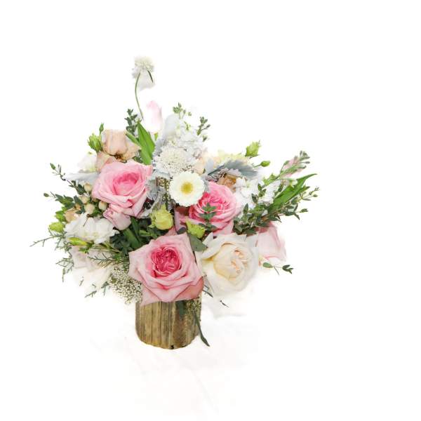 Pink and white rose bouquet in a rustic wooden container