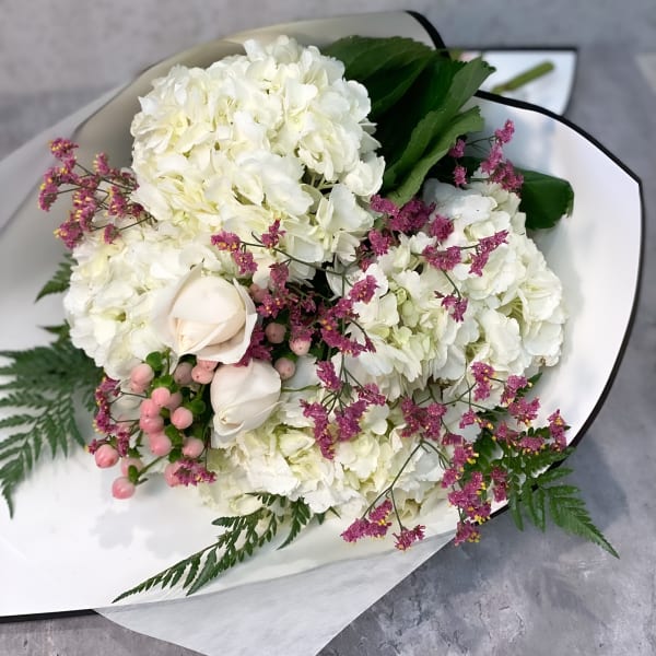 White hydrangea bouquet with pale roses and pink filler flowers