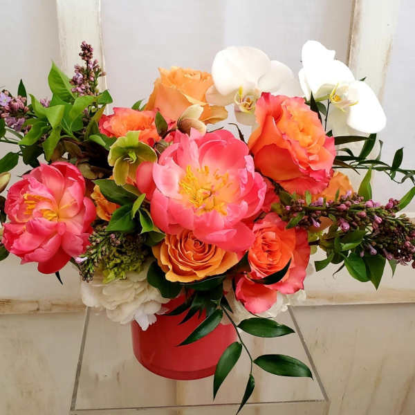 Bright bouquet of pink and orange flowers in a red container