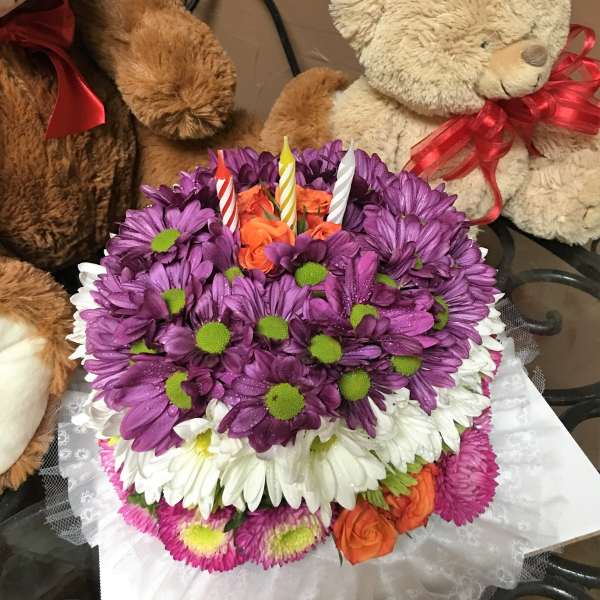 Purple and white daisy bouquet with orange roses and birthday candles