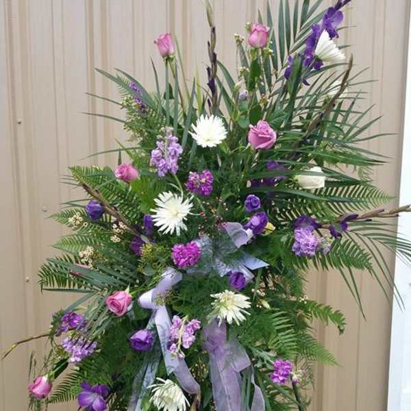 Tall standing floral spray with pink and purple flowers on a metal easel