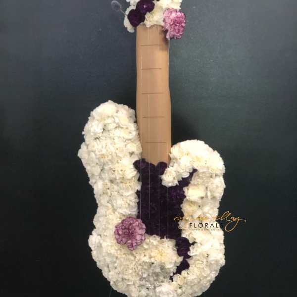 White and purple floral arrangement shaped like a guitar