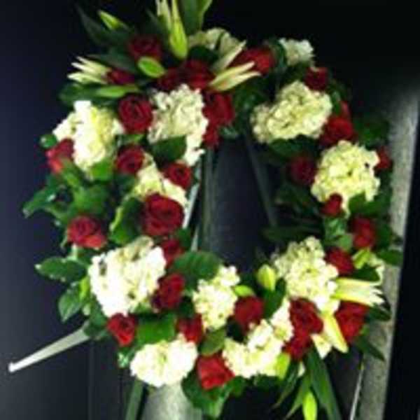 Heart-shaped wreath of red roses and white flowers