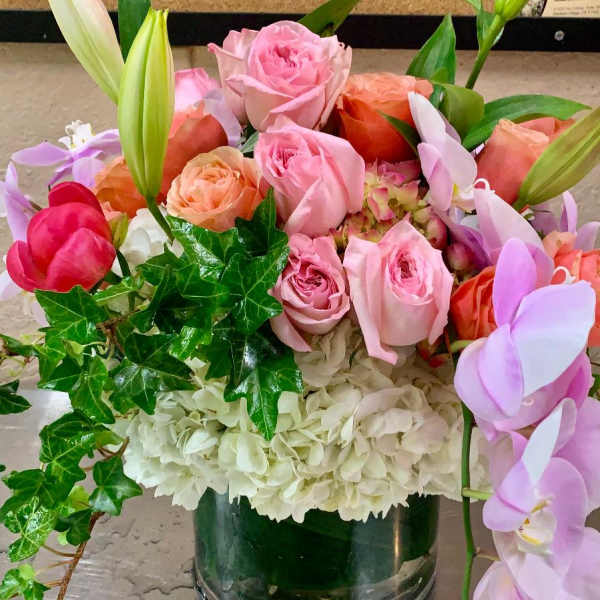 Pink and peach roses with white hydrangeas in a glass vase