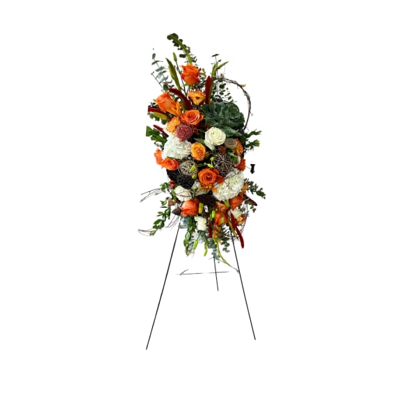 Tall floral standing spray with orange and white roses on an easel