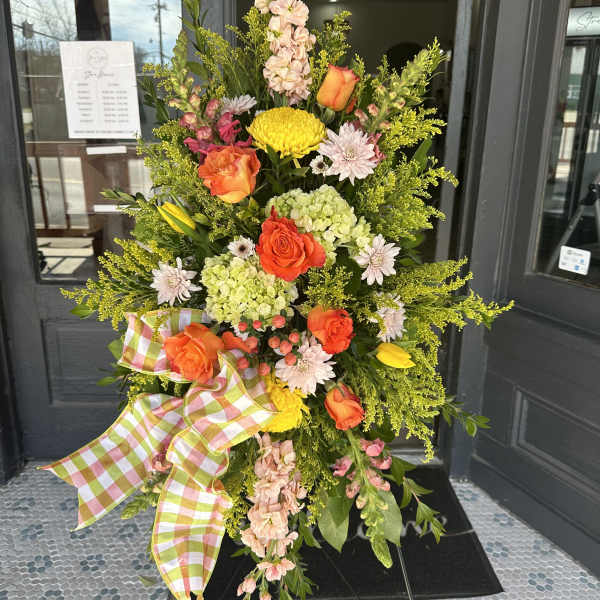Tall floral standing spray with orange roses and yellow chrysanthemums