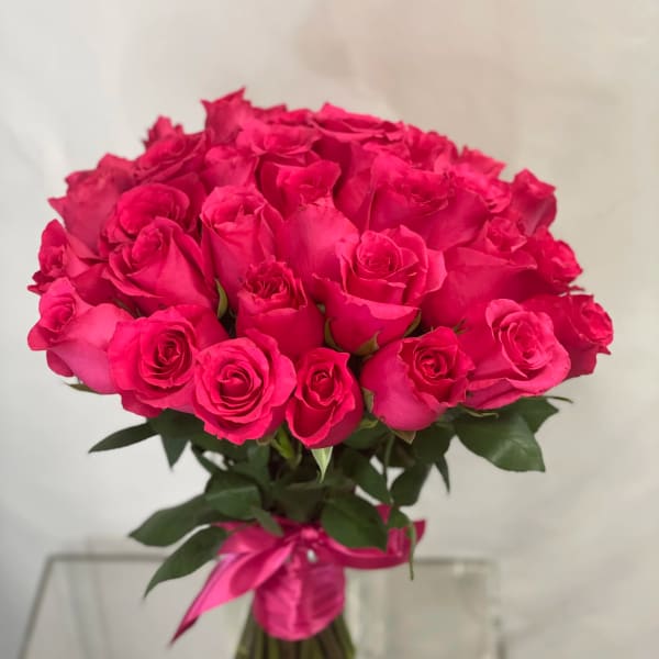 Bouquet of bright pink roses tied with a pink ribbon