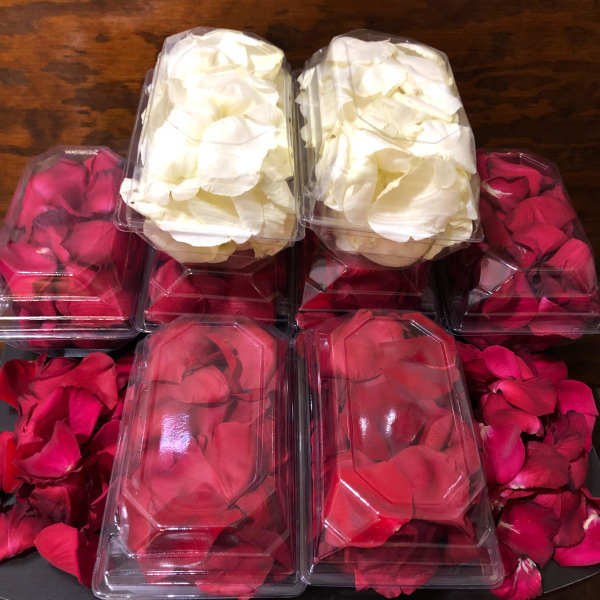 Plastic boxes filled with red and white rose petals