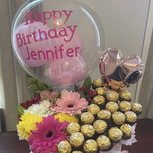 Birthday balloon arrangement with flowers and chocolates