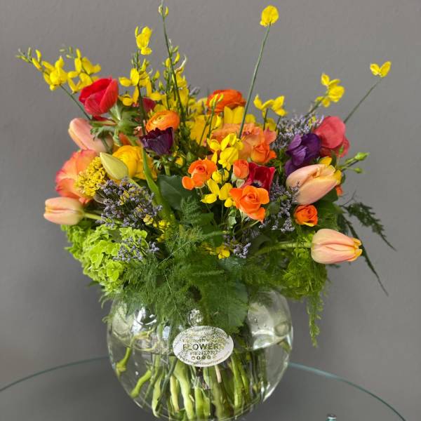 Colorful mixed bouquet in a round glass vase